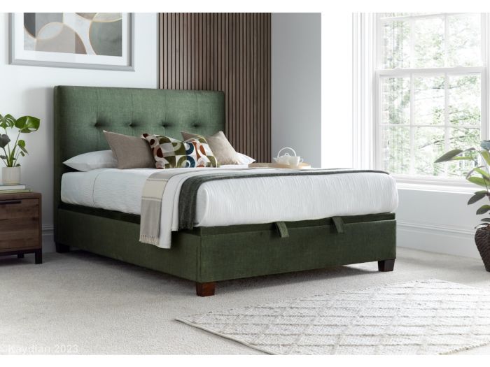 Luxurious moss green velvet ottoman bed frame with modern dark wooden feet.