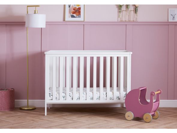 Modern, white mini cot bed with open slatted sides and 3 base heights. Crafted from pine.